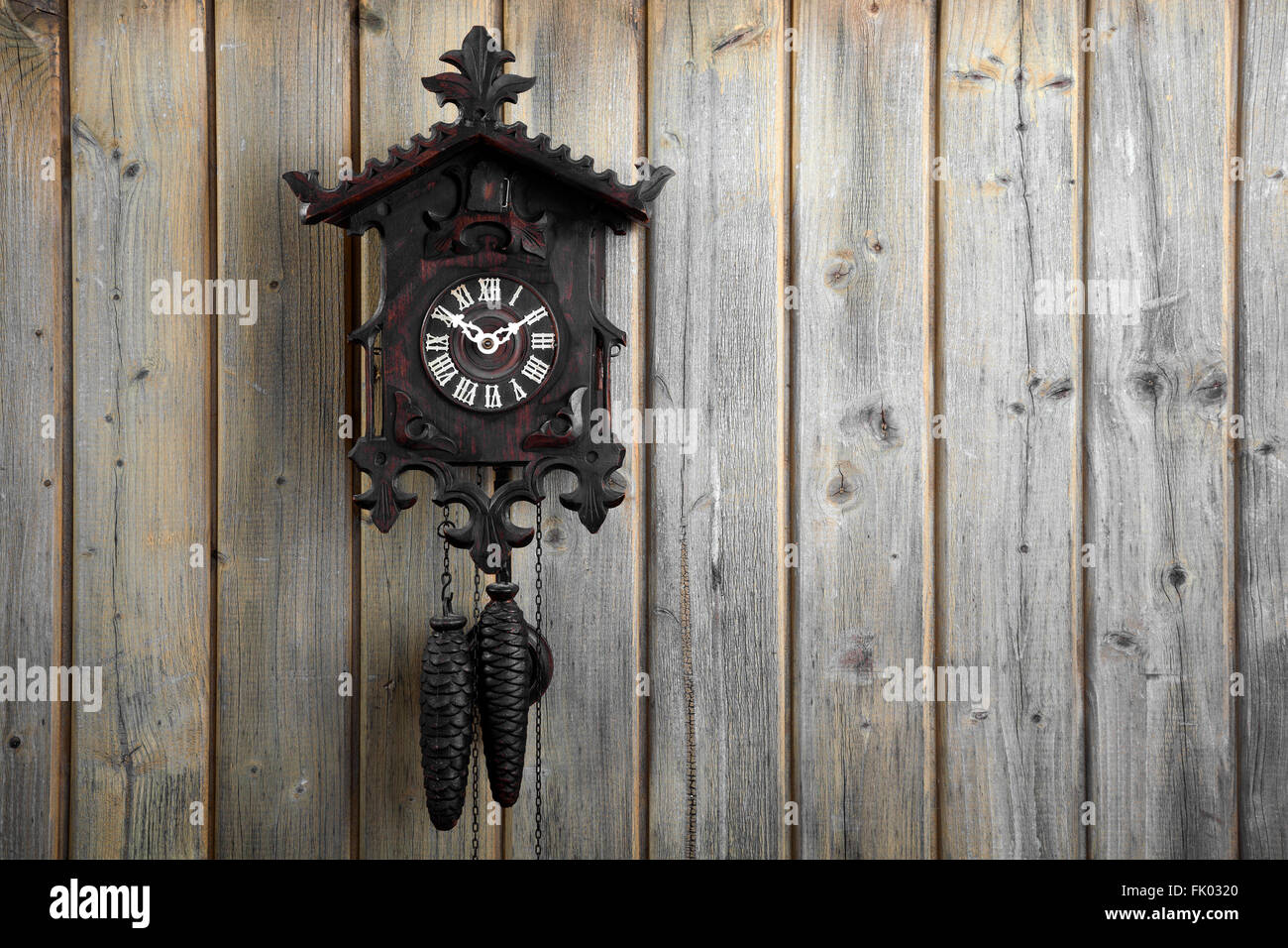 Vieille horloge coucou de la Forêt Noire, sur un mur en bois, Allemagne Banque D'Images