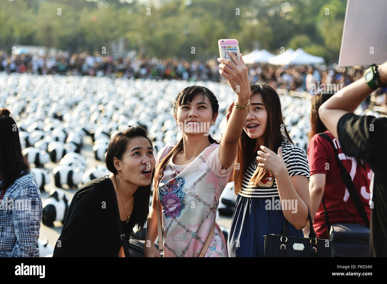 (160304) -- BANGKOK, 4 mars 2016 (Xinhua) -- trois filles selfies posent pour une lors d'une exposition d'art papier mâché le '1600' des pandas à la place Sanam Luang, à Bangkok, Thaïlande, le 4 mars 2016. "1600 Pandas", une oeuvre papier mâché créé en 2008 par l'artiste français Paulo Grangeon pour le Fonds mondial pour la nature (WWF), a commencé sa tournée de l'exposition de la Thaïlande le vendredi dans un premier flash-mob spectacle à Bangkok du Sanam Luang carré qui a duré trois heures. Les 1 600 pandas en papier sera montrée à neuf plus d'arrêts à Bangkok et Ayutthaya avant la tournée de l'exposition se termine le 10 avril. (Xinhua/Li Banque D'Images