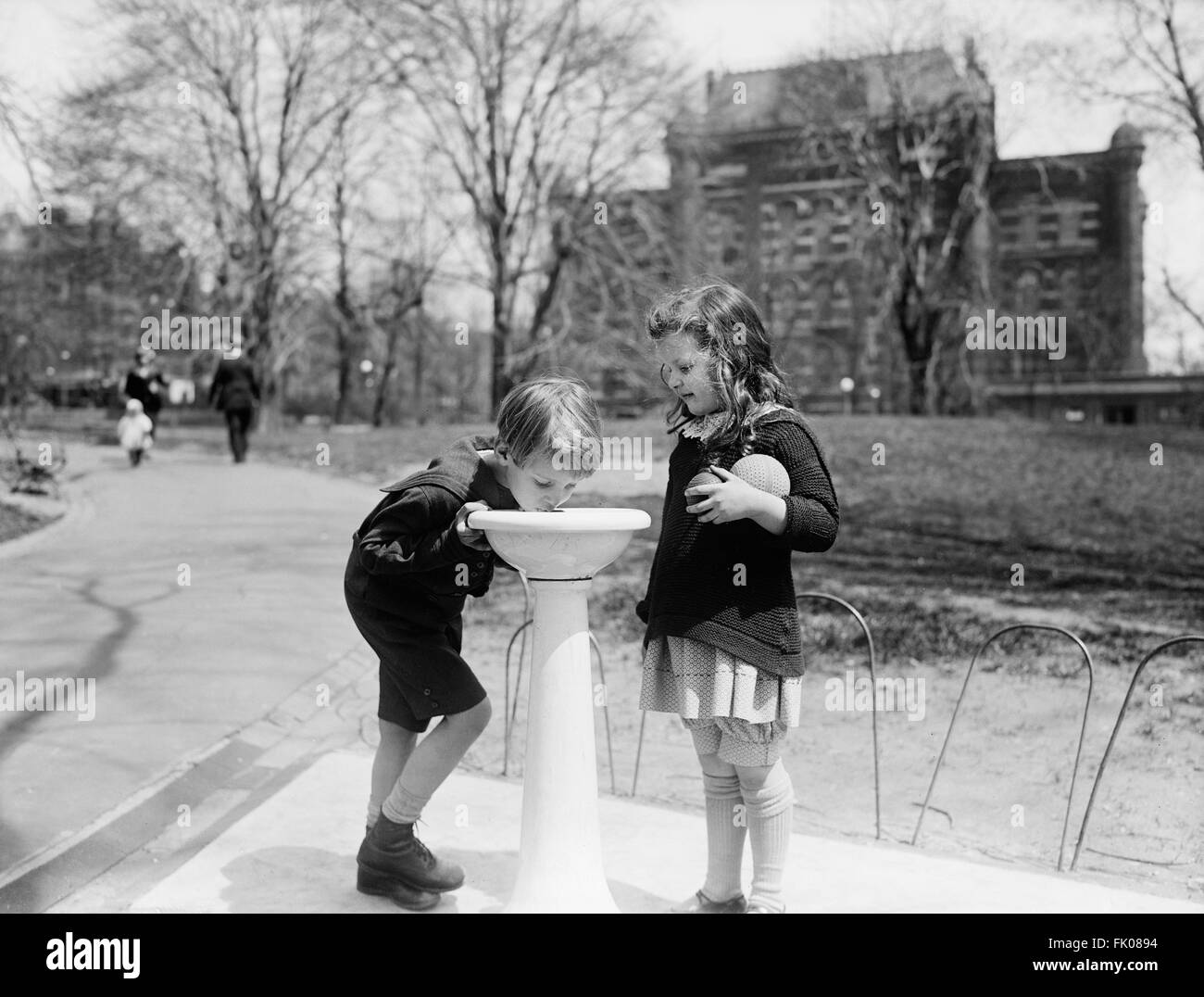 Deux enfants à la fontaine à eau en Park, Washington DC, USA, vers 1924 Banque D'Images