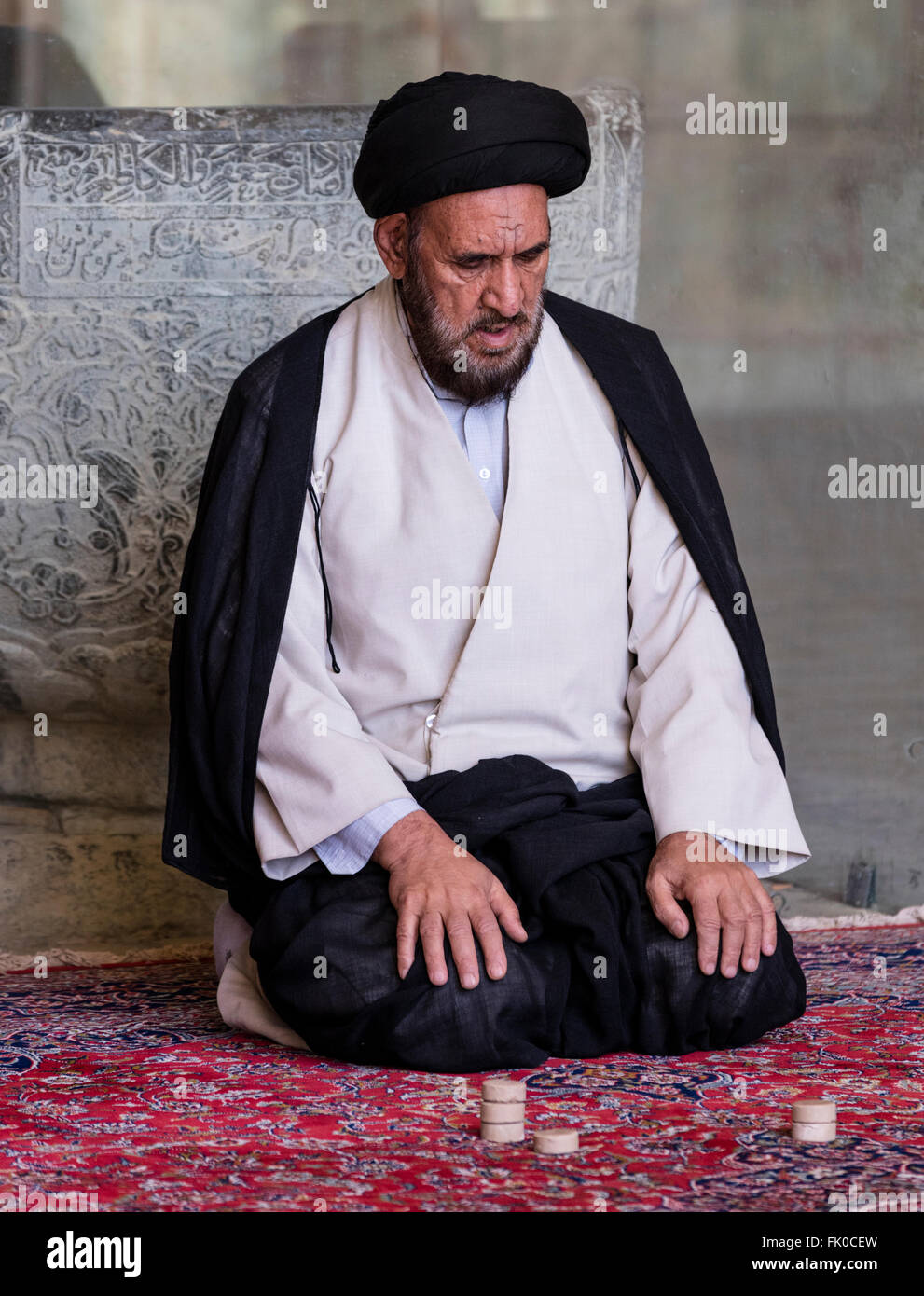 Le mollah Chiite musulmane en turban et une blouse assis en prière dans la Masjed-e Jame (mosquée du vendredi), Isfahan, Iran Banque D'Images