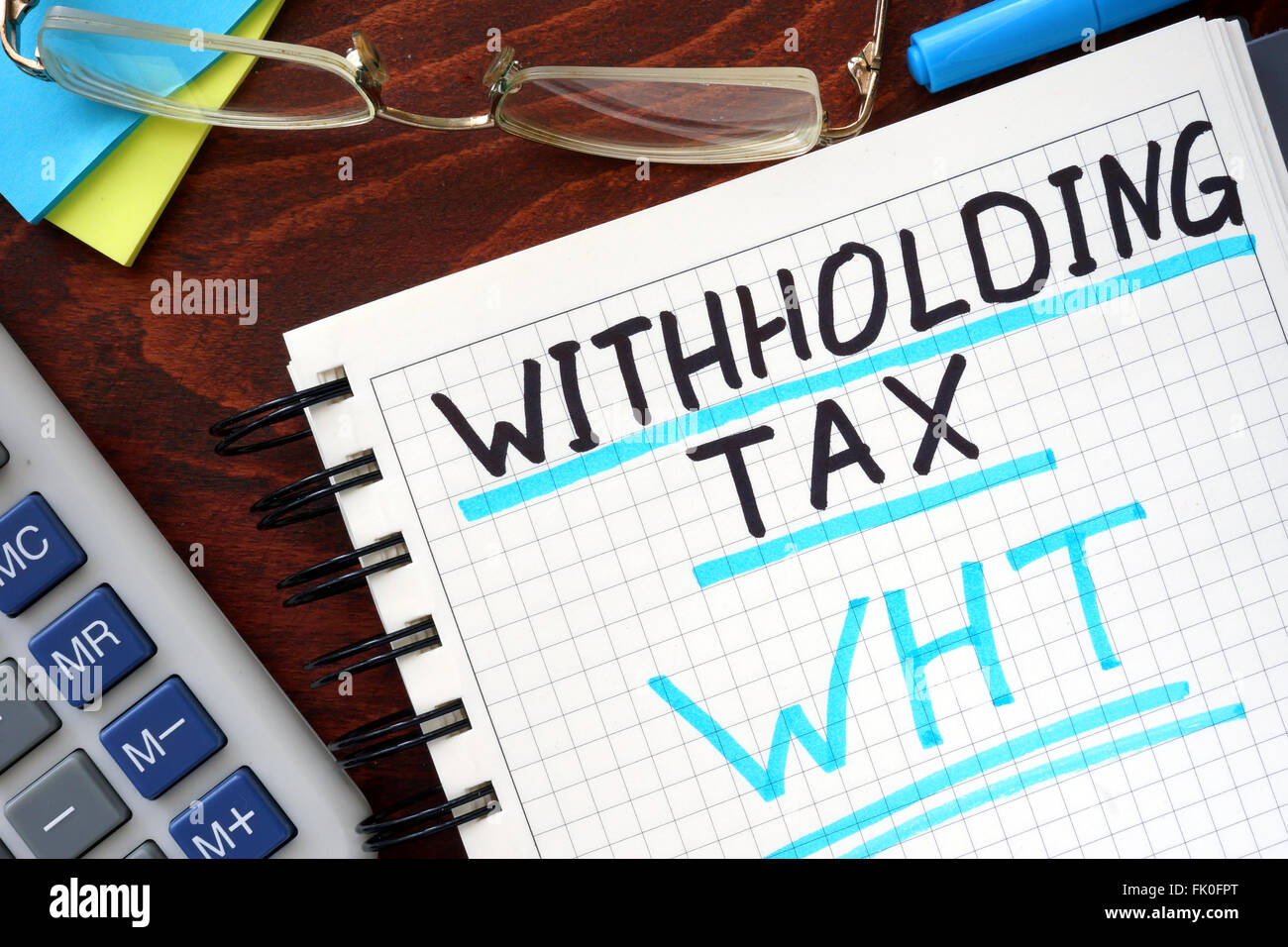 Whithholding concept blanc impôt écrit dans un ordinateur portable sur une table en bois. Banque D'Images