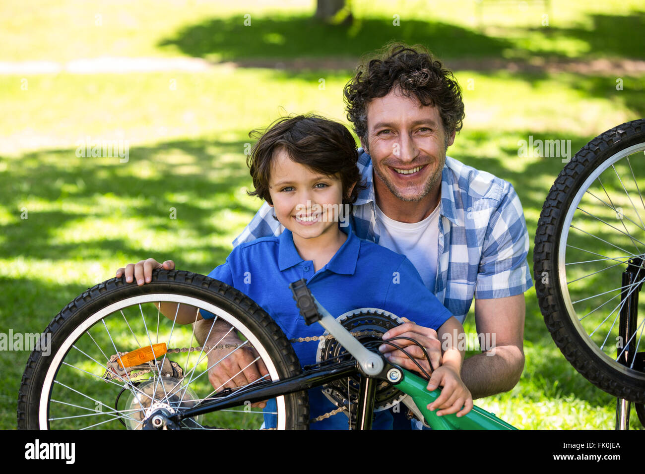 Père et fils fixant le vélo Banque D'Images