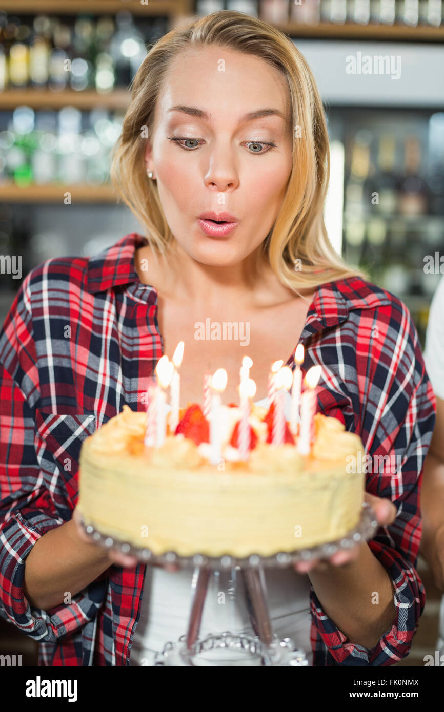 Woman blowing out candles Banque D'Images