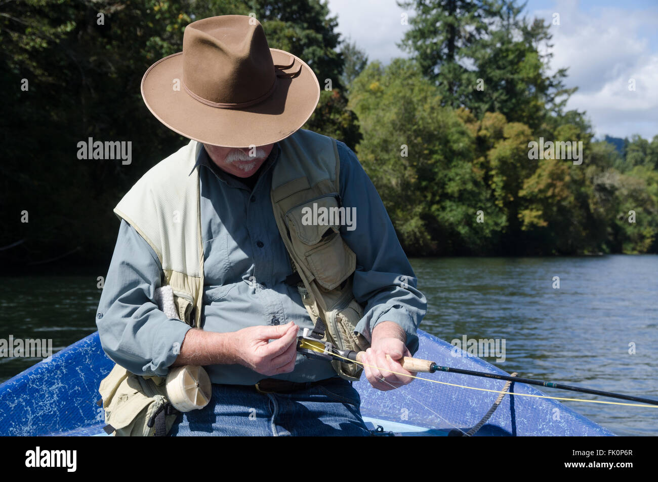 A senior man se concentre alors qu'il se prépare sa ligne pour la pêche. Banque D'Images