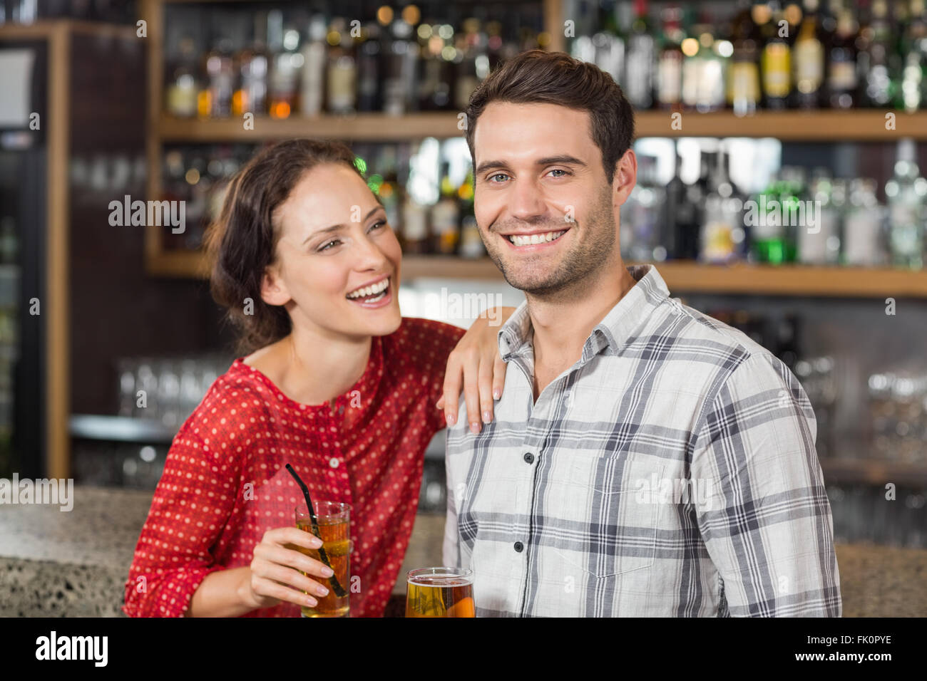 Couple smiling at camera et holding beers Banque D'Images