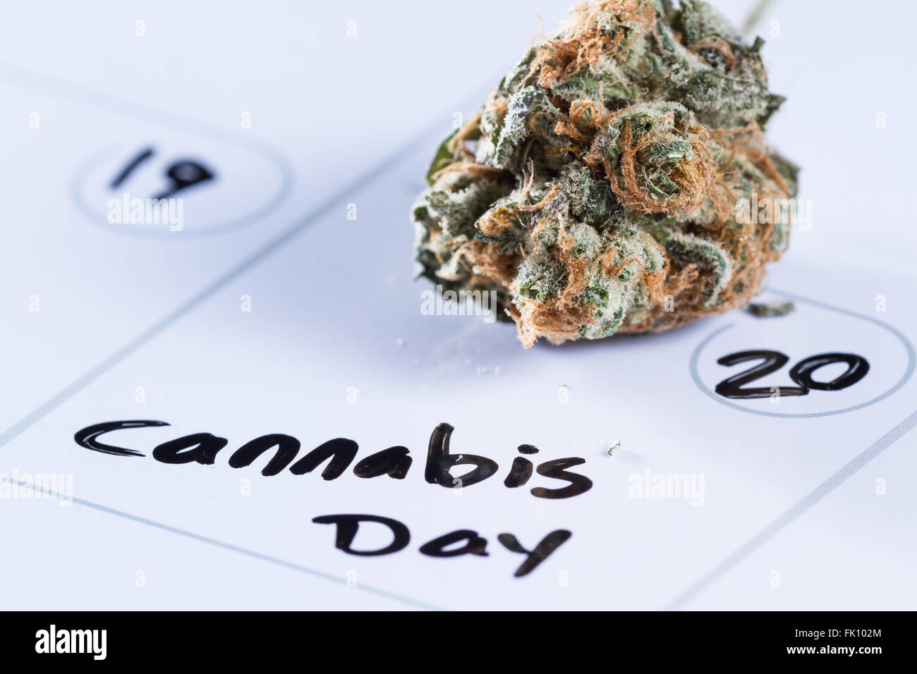 Close up image pour un concept à l'aide d'un calendrier, un bourgeon de cannabis et un marqueur noir pour écrire les mots jour cannabis Banque D'Images