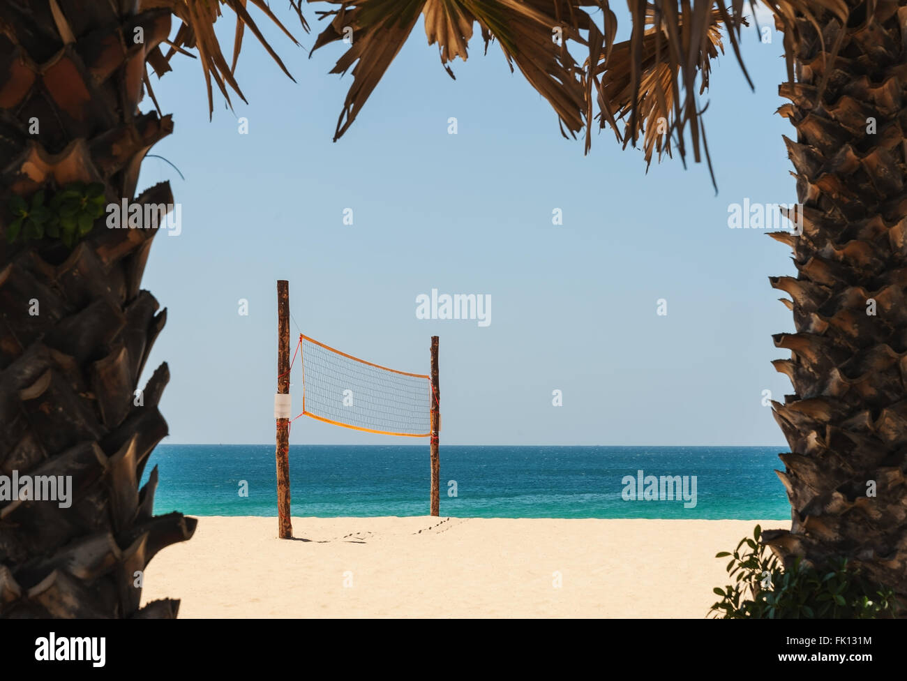 Filet de volley-ball sur plage de sable blanc et de mer tropicale dans la lumière du midi avec tree border Banque D'Images