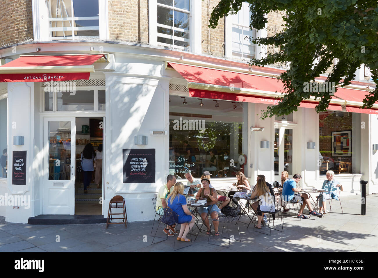 Les gens se détendre dans des tables, près de cafe à Portobello Road à Londres en été Banque D'Images