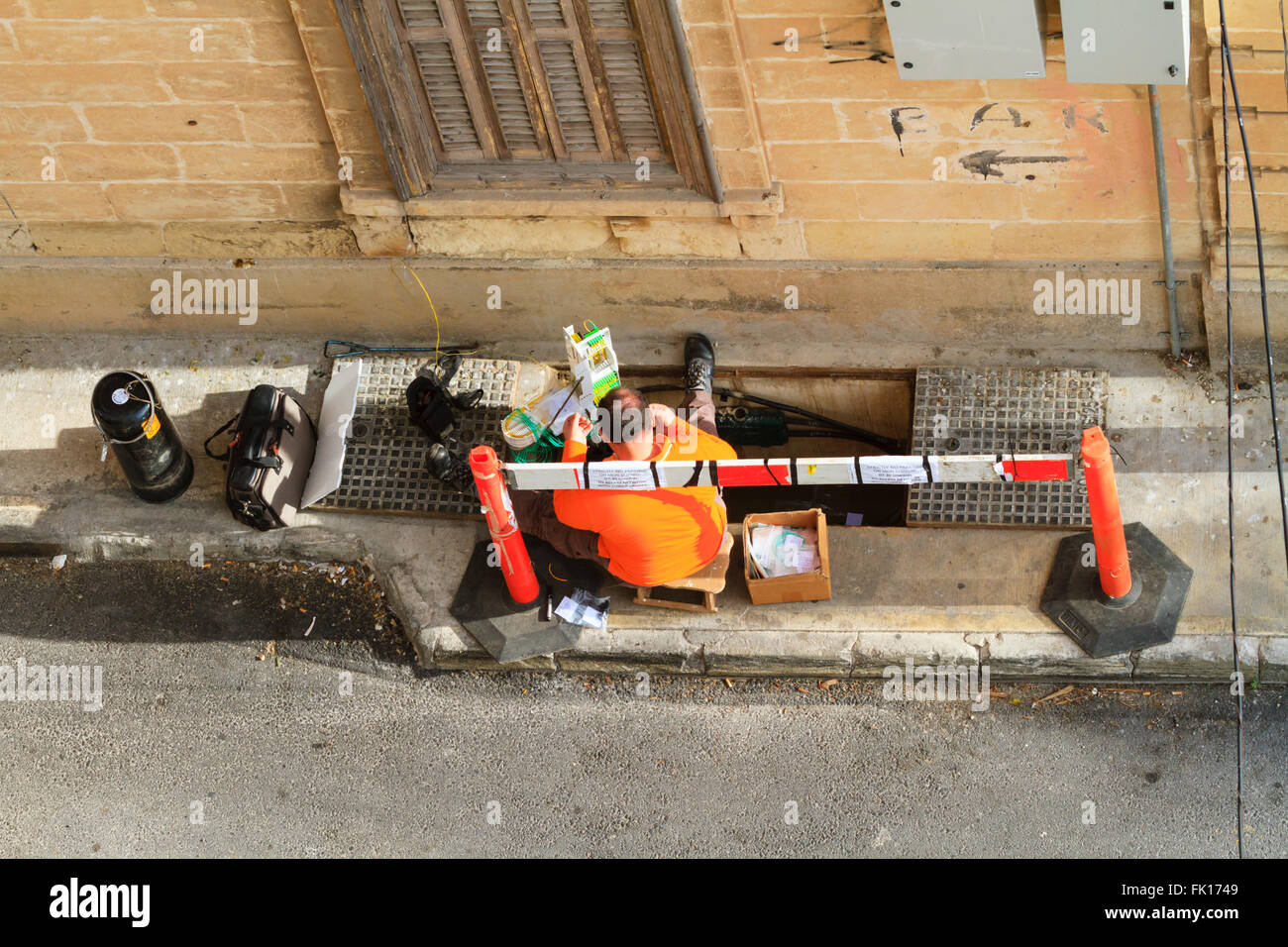 Ingénieur en Télécommunications maltais de la réparation des câbles à fibres optiques dans une rue latérale dans Tas Sliema, La Valette, Malte. Banque D'Images