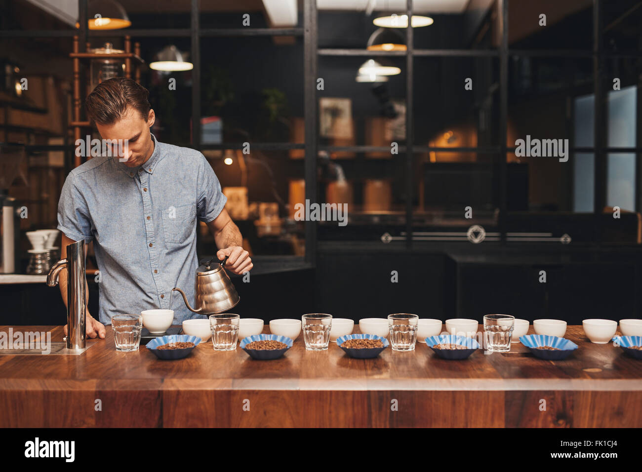 Dégustation de café barista la préparation avec des rangées de tasses et de haricots Banque D'Images