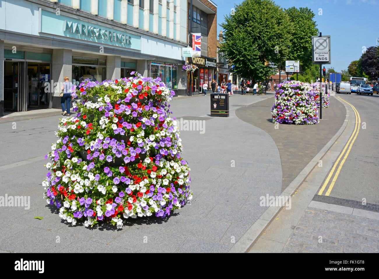 Brentwood town center shopping High Street large trottoir avec fleurs d'été en face de fleurs magasin Marks & Spencer par conseil local Banque D'Images