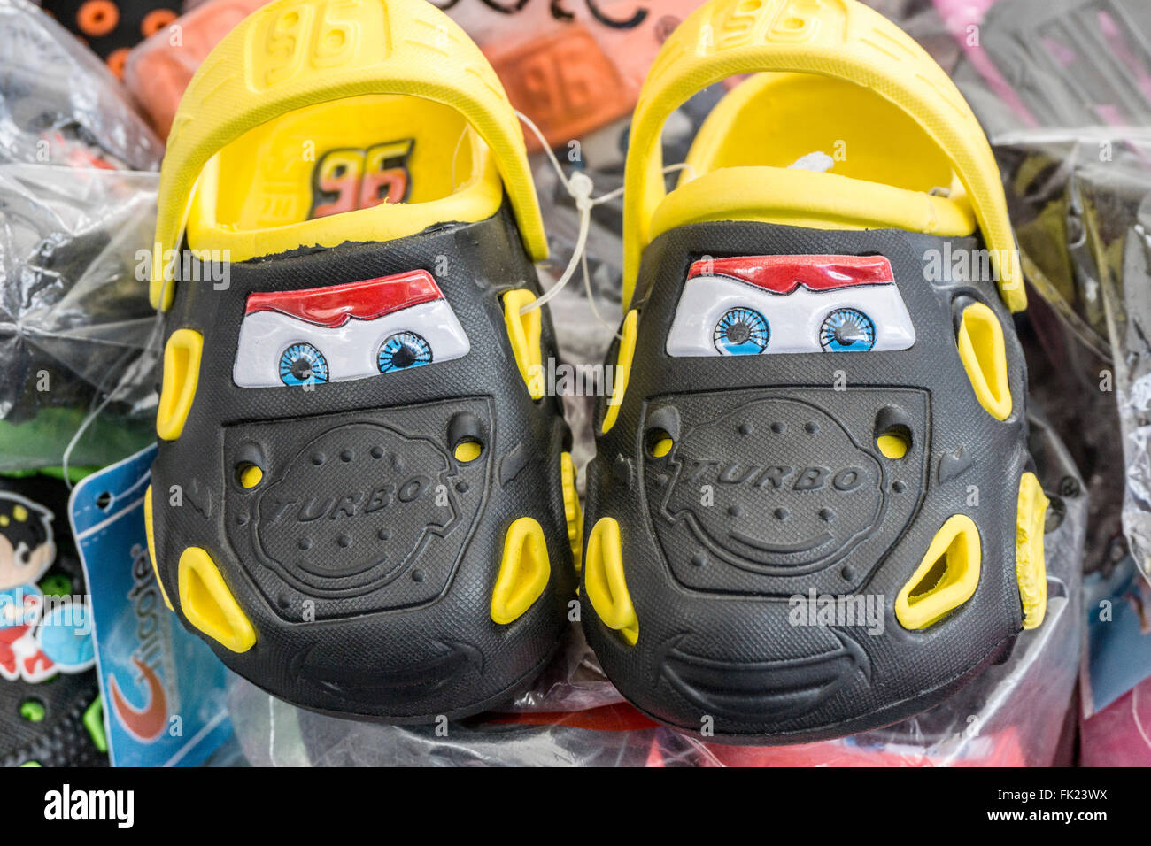 Afficher la nouveauté de l'enfant intelligent paire de crocs conçu pour ressembler à des voitures avec deux yeux bleu vif sur les pare-brise avant Banque D'Images