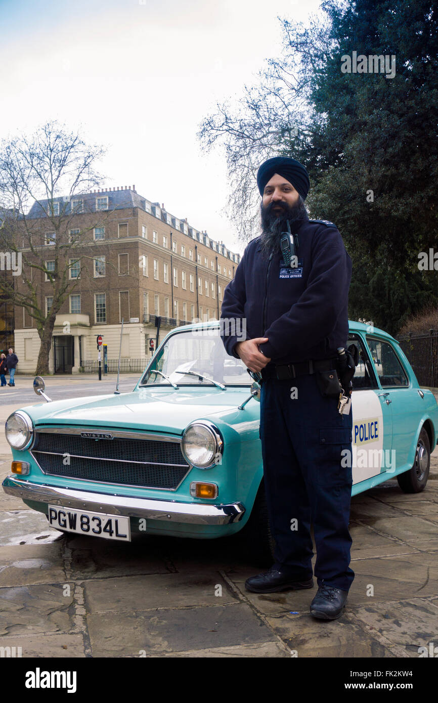 Un policier Sikh debout à côté d'une vieille voiture panda à Bloomsbury Banque D'Images