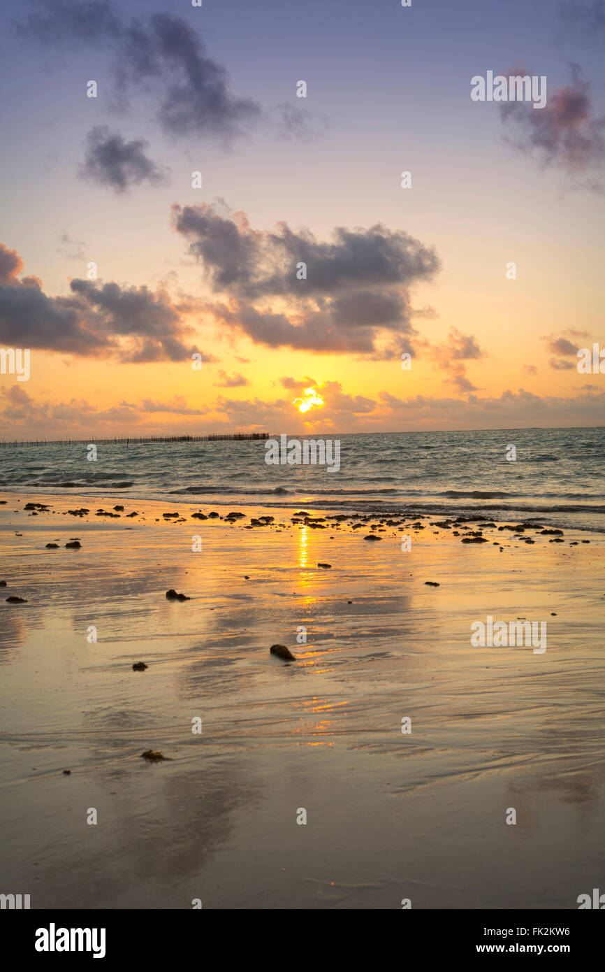 Le soleil se lève sur une plage vide et l'océan est ouvert Banque D'Images