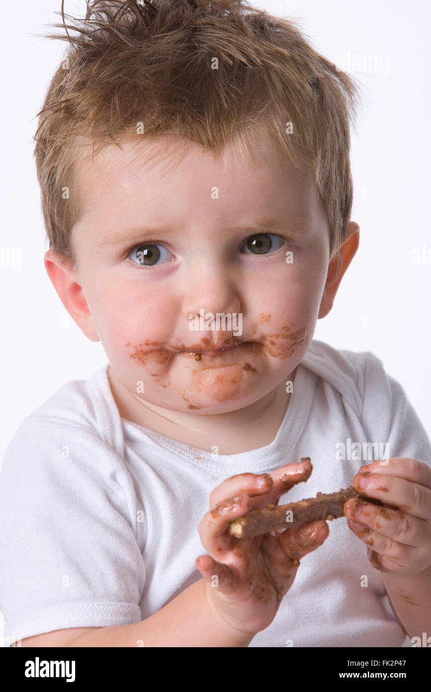 Petit Bebe Garcon Est En Train De Manger Une Collation Au Chocolat Sur Fond Blanc Photo Stock Alamy
