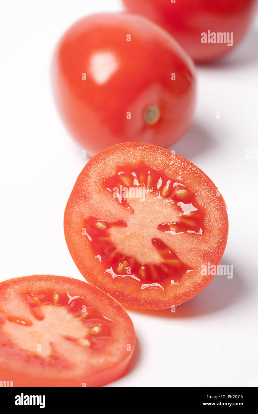 Ensemble et la moitié des tomates rouges sur fond blanc Banque D'Images