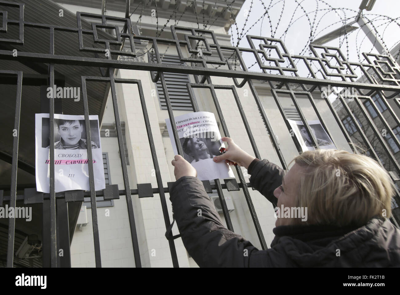 La femme attache portraits de pilotes de l'Ukraine dans l'avant Nadia Savchenko un bâtiment de l'ambassade de Russie au cours d'une manifestation à Kiev, Ukraine, le 06 mars 2016. 21 Jan, 2016. © Michel Stepanov/ZUMA/Alamy Fil Live News Banque D'Images