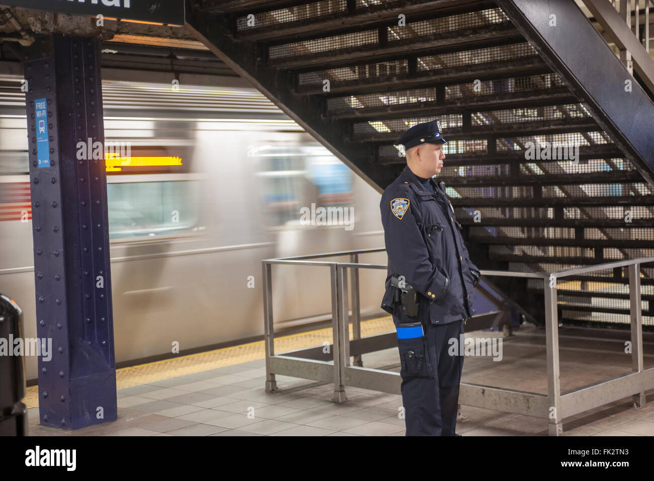 Un officier du NYPD est vu dans la station de Times Square à New York, le mercredi 2 mars 2016. Le NYPD a annoncé un effort de lutte contre la flambée dans les crimes, en particulier d'automutilation, dans le métro en ayant plus d'agents sur les trains et les plates-formes. Un responsable sera sur chaque train de 8h00 à 16h00, un plan qui a été utilisé il y a quelques années. La criminalité dans le métro est une hausse de 25  % par rapport à l'année dernière. (© Richard B. Levine) Banque D'Images
