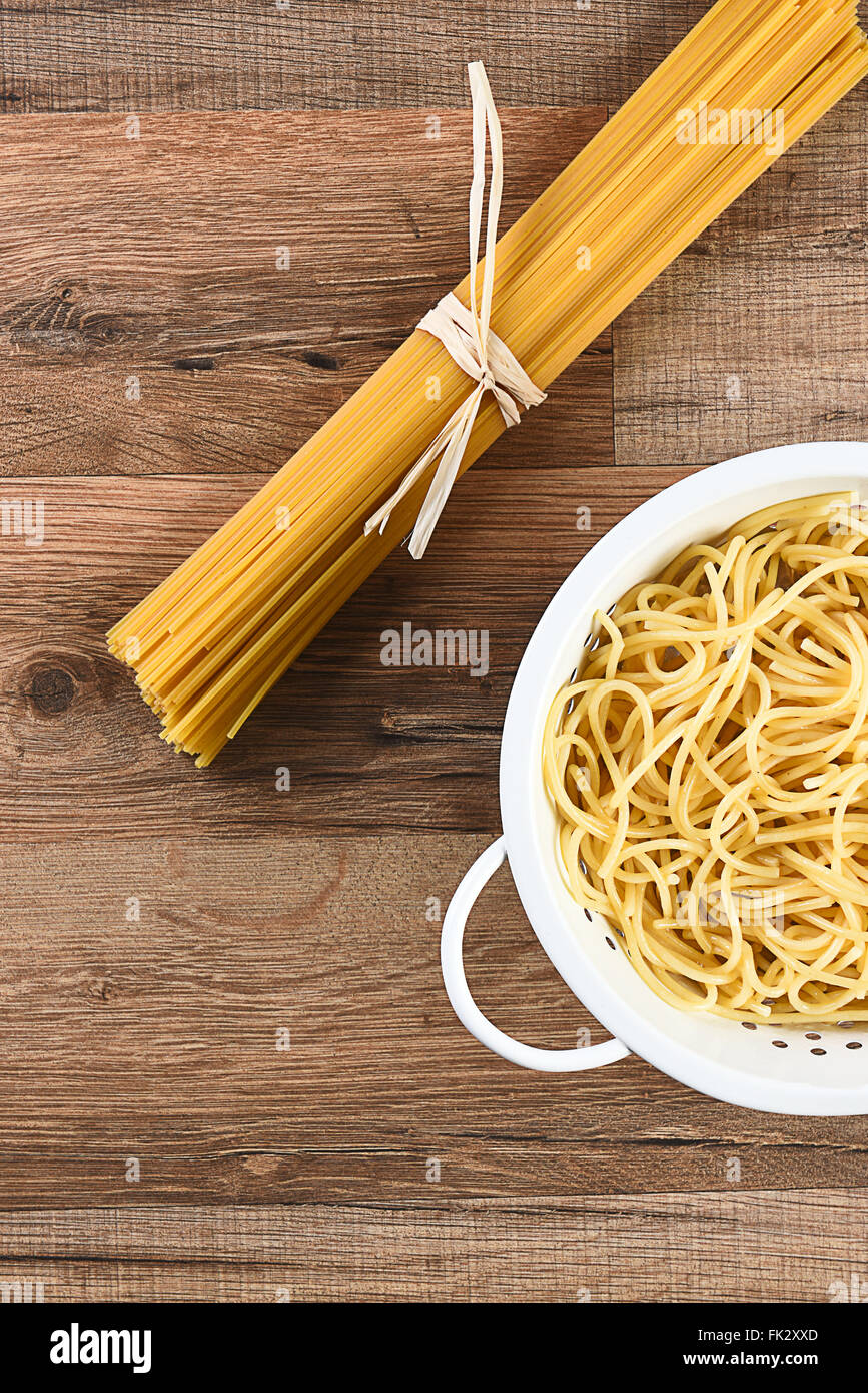 Vue aérienne de spaghetti cuit et séché. Les pâtes cuites est dans une passoire et le raw est avec du raphia. Sur un horizontal Banque D'Images