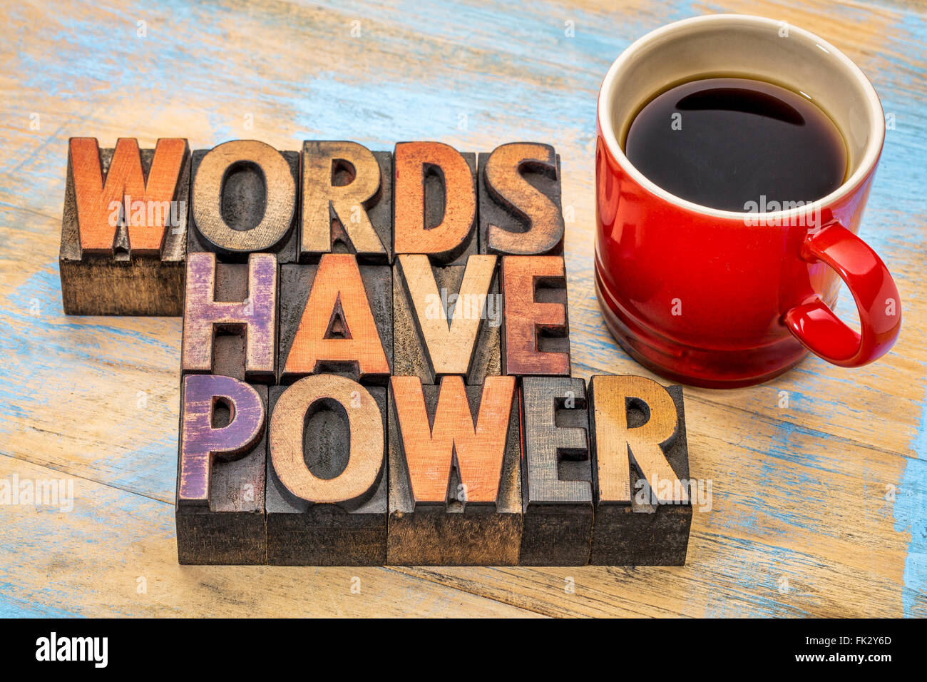 Les mots ont un pouvoir de phrase dans la typographie vintage type bois souillé par des blocs d'impression aux encres de couleur avec une tasse de café Banque D'Images