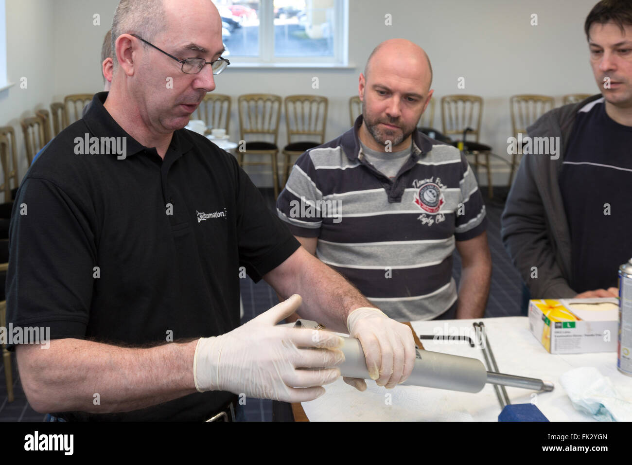 Les hommes adultes enseignés l'ingénierie et la pneumatique par ingénieur diplômé de l'instructeur. Banque D'Images