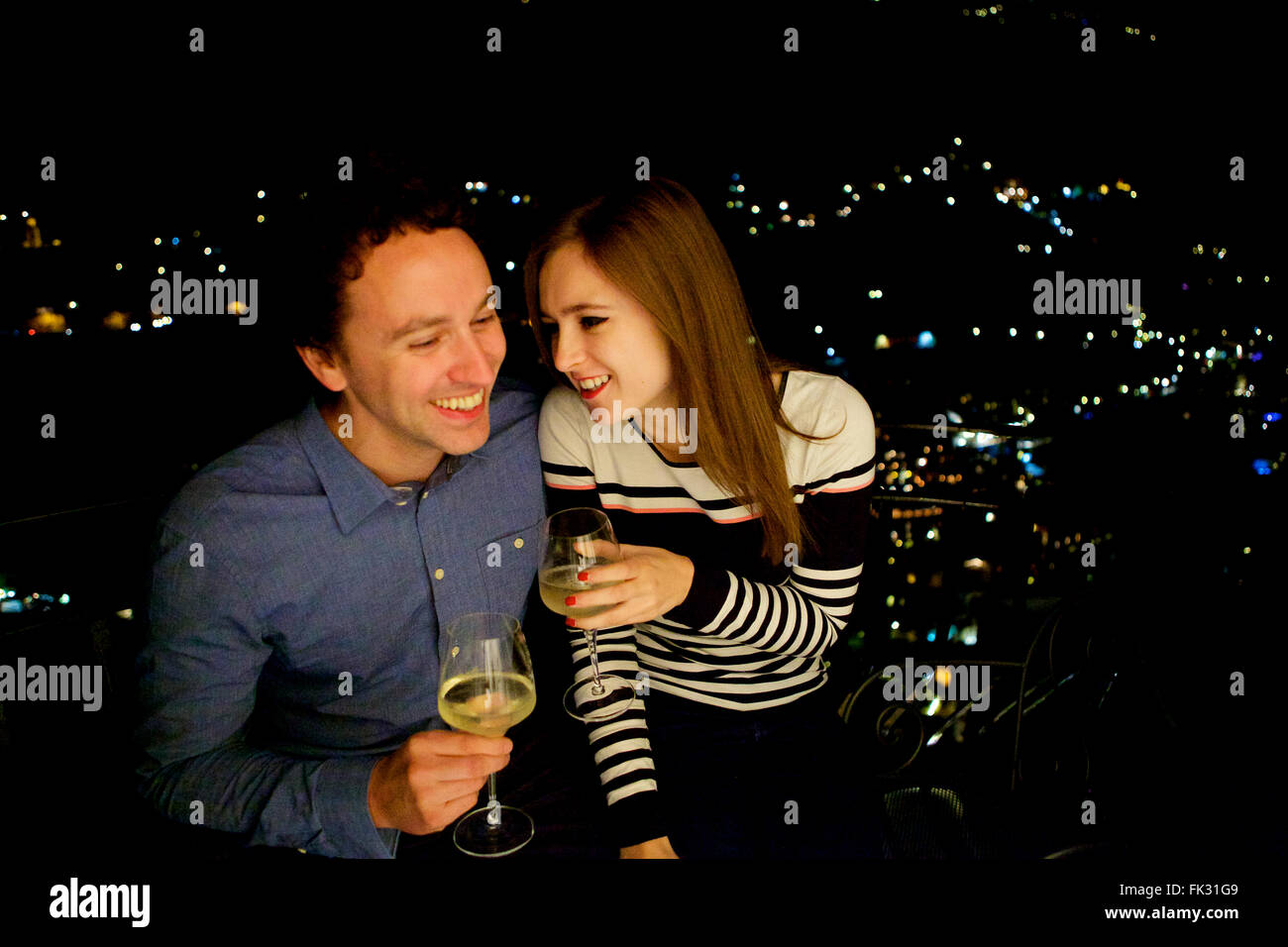Les jeunes et dans l'amour brunette en vacances en Italie, côte amalfitaine, célébrer avec un verre sur le balcon de nuit Banque D'Images