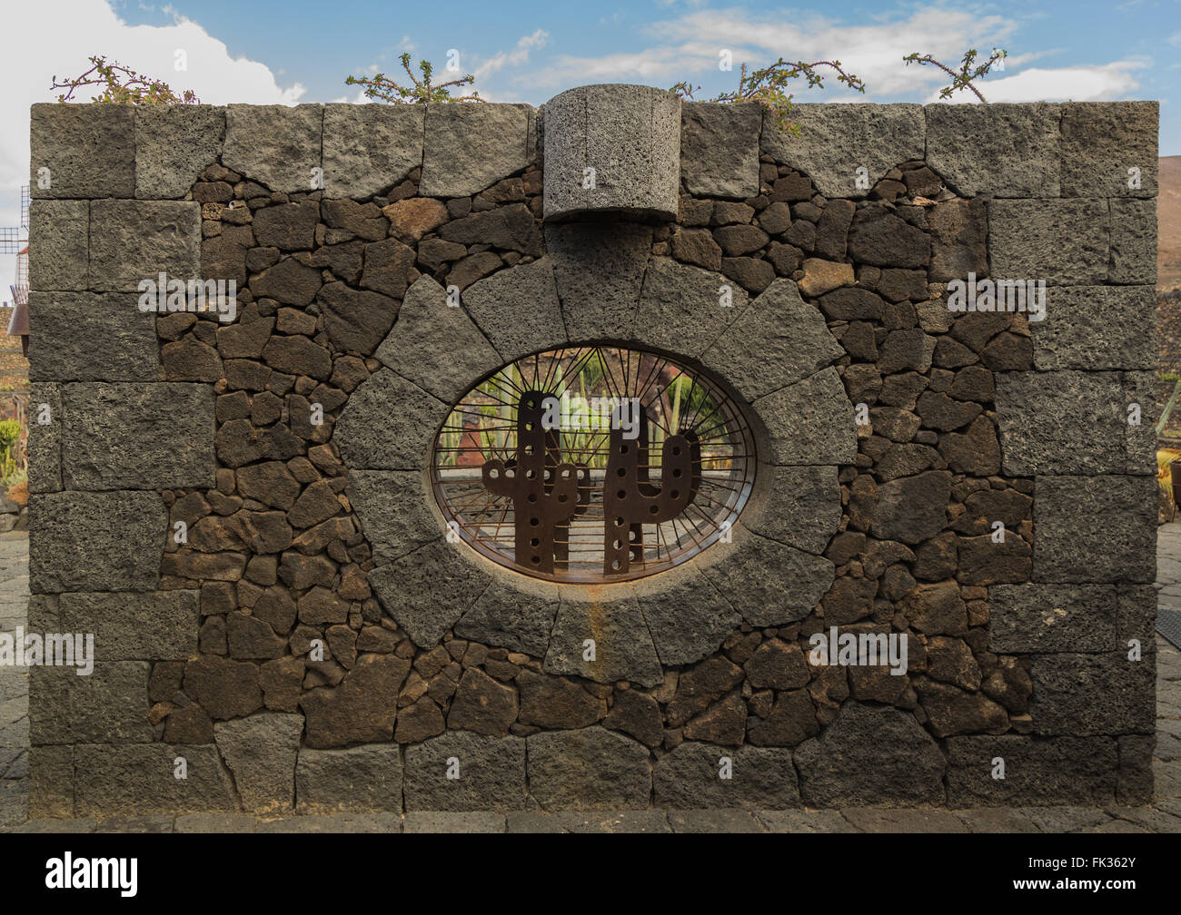 Mur de pierre avec fenêtre cactus au à l'entrée du jardin de cactus de Lanzarote. Conçue par César Manrique. Banque D'Images