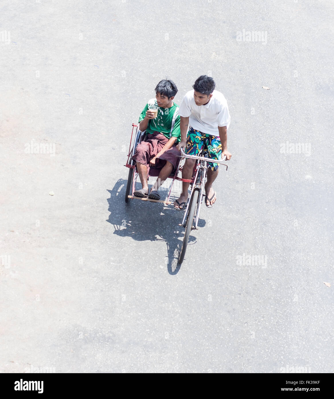 Les hommes en vélo dans les rues de la ville Yangon Banque D'Images