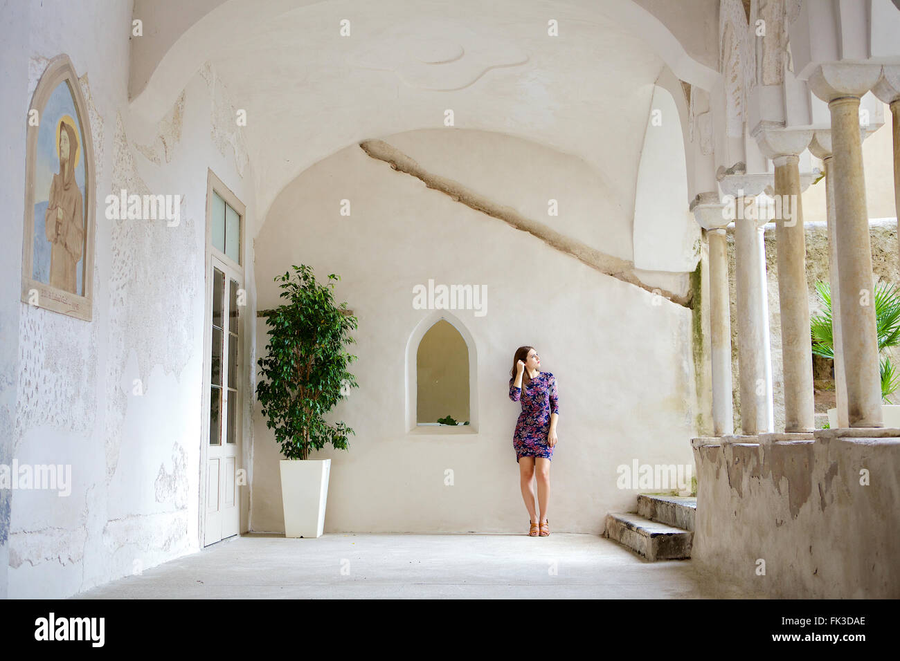 Une jeune femme brune dans le cadre d'un beau, vieux, bâtiment italien méditerranéen. Dans son entourage, Côte Amalfitaine. Banque D'Images