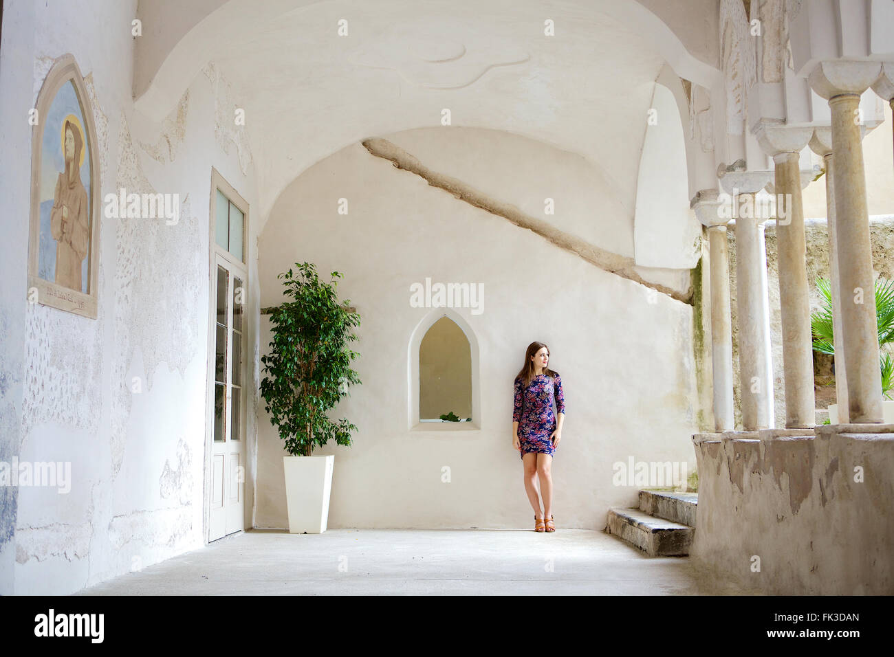 Une jeune femme brune dans le cadre d'un beau, vieux, bâtiment italien méditerranéen. Dans son entourage, Côte Amalfitaine. Banque D'Images