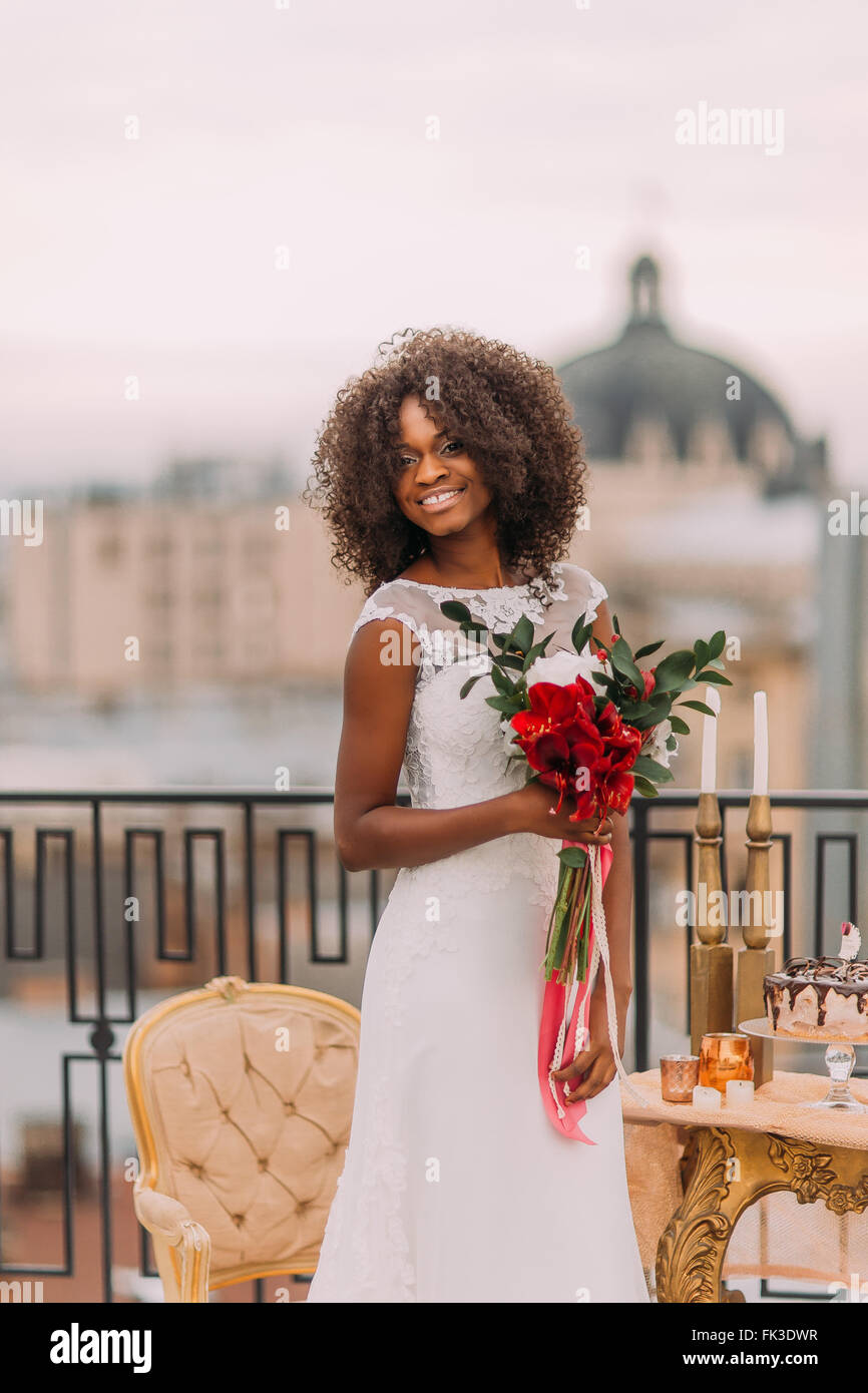 Belle mariée africaine avec mariage bouquet sur le toit avec l'ancienne architecture européenne sur l'arrière-plan Banque D'Images