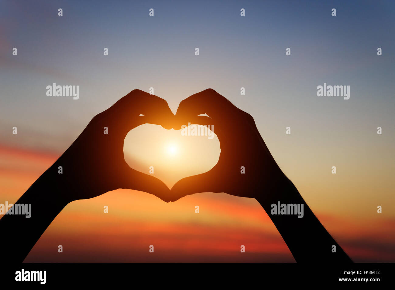 Geste main silhouette ressentir de l'amour durant le coucher du soleil Banque D'Images