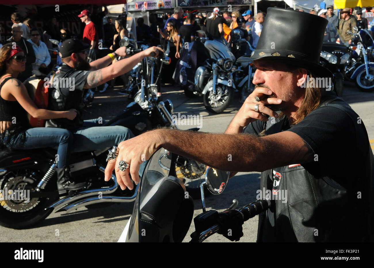 Daytona Beach, Floride, USA. 06 Mar, 2016. Un homme sur une moto fume un  cigare tout en regardant d'autres motards en descendant la rue Main à  Daytona Beach, en Floride, pour la
