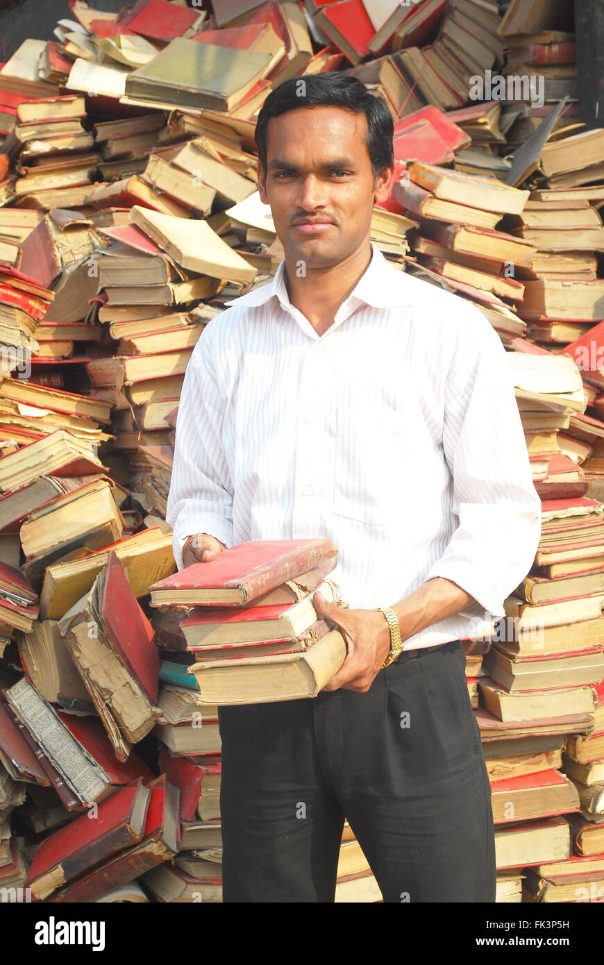 Le choix de l'étudiant à partir de la pile de livres poussiéreux Banque D'Images