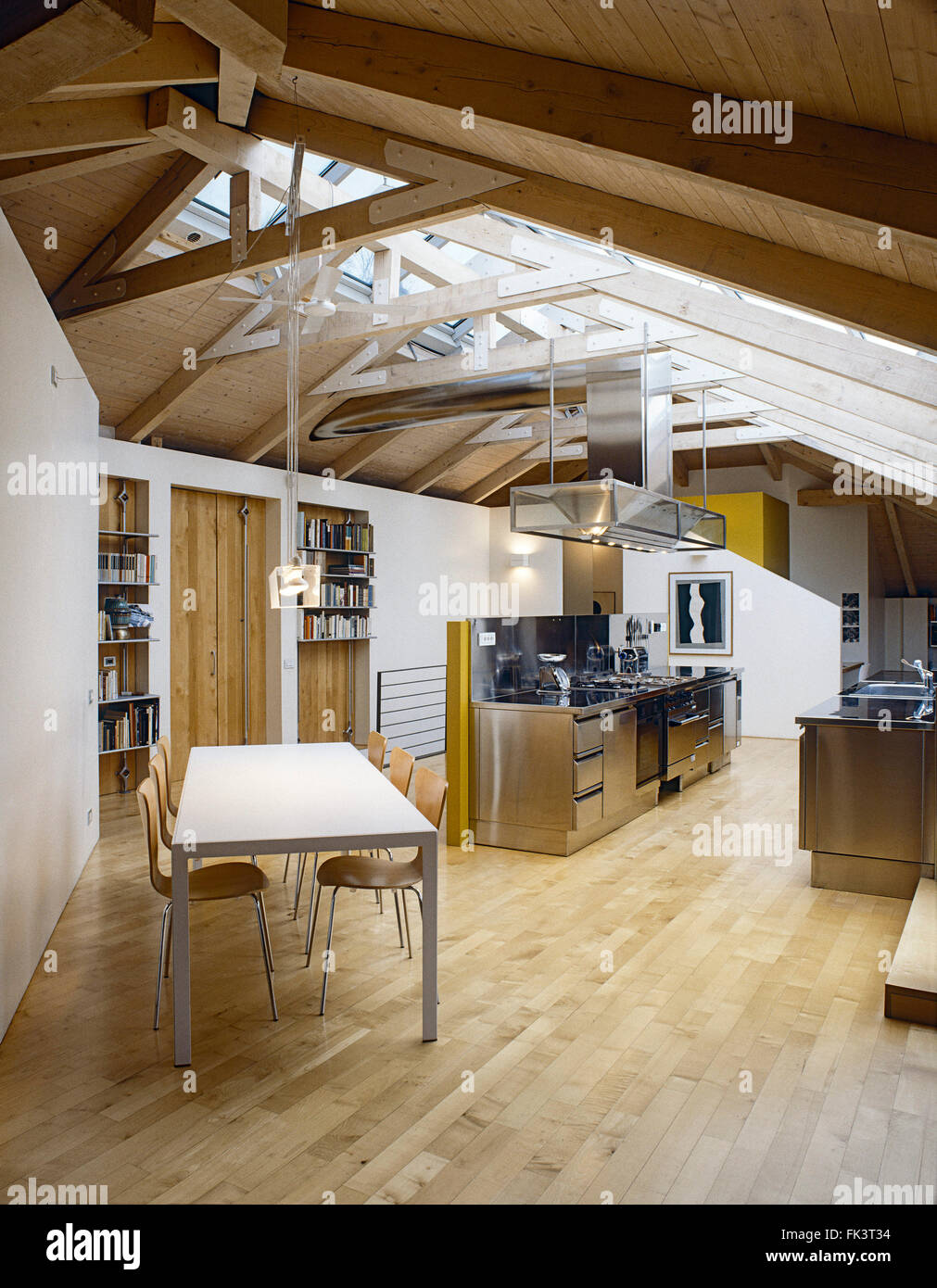 Vue intérieure d'une cuisine moderne et salle à manger dans la chambre mansardée avec parquet et trussed de bois Banque D'Images