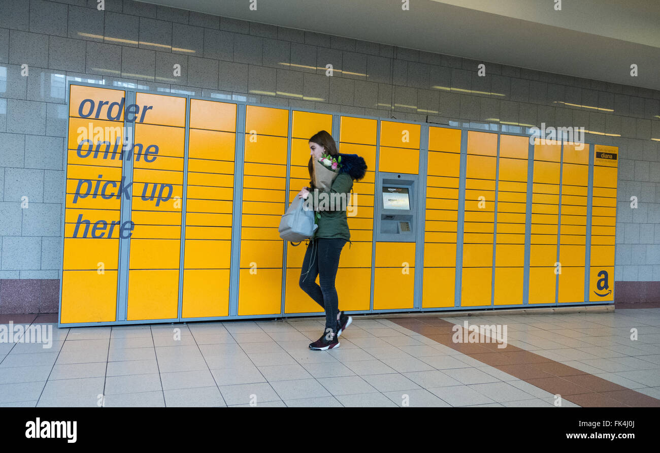 Une jeune femme ramasse des fleurs dans un kiosque libre-service Amazon du centre commercial Hammersmith Broadway, Londres, Angleterre, Royaume-Uni. Banque D'Images