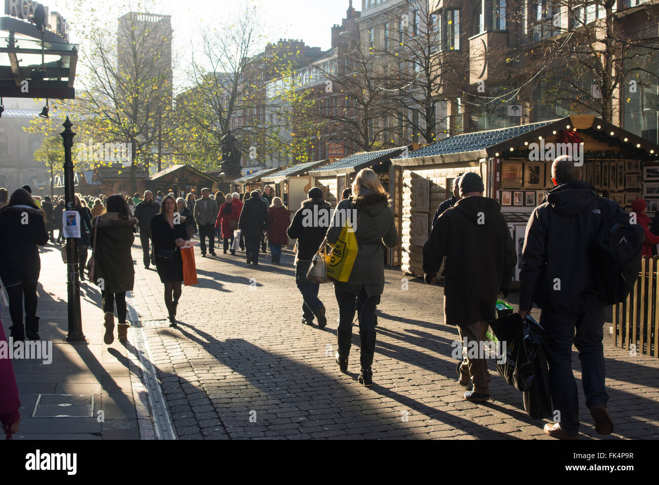 Clients mystères de St Anne's Square Manchester profitant du soleil d'hiver. Banque D'Images