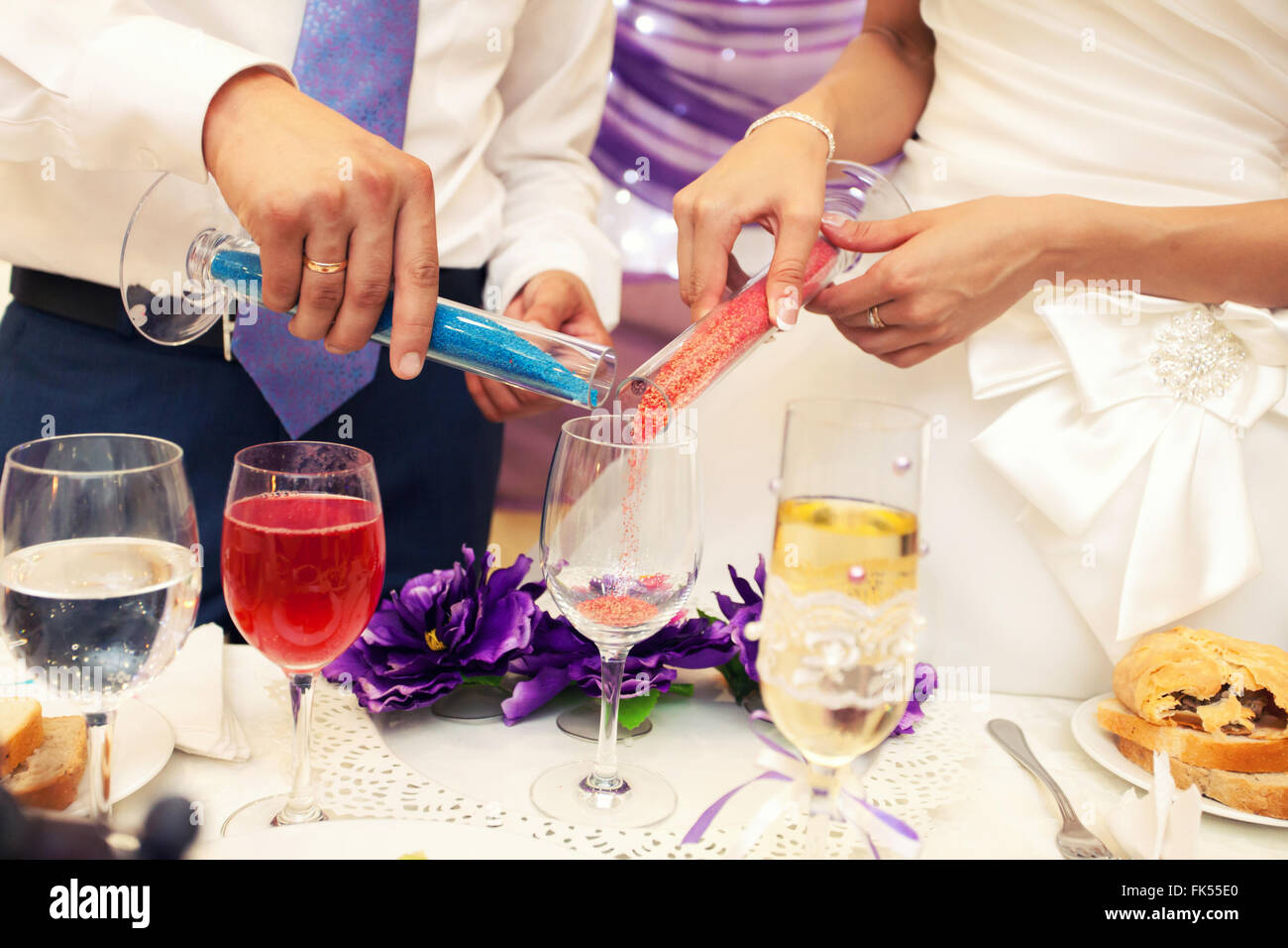 Jeunes mariés lors de la cérémonie du sable à un mariage Banque D'Images Jeunes mariés lors de la cérémonie du sable à un mariage Banque D'Images