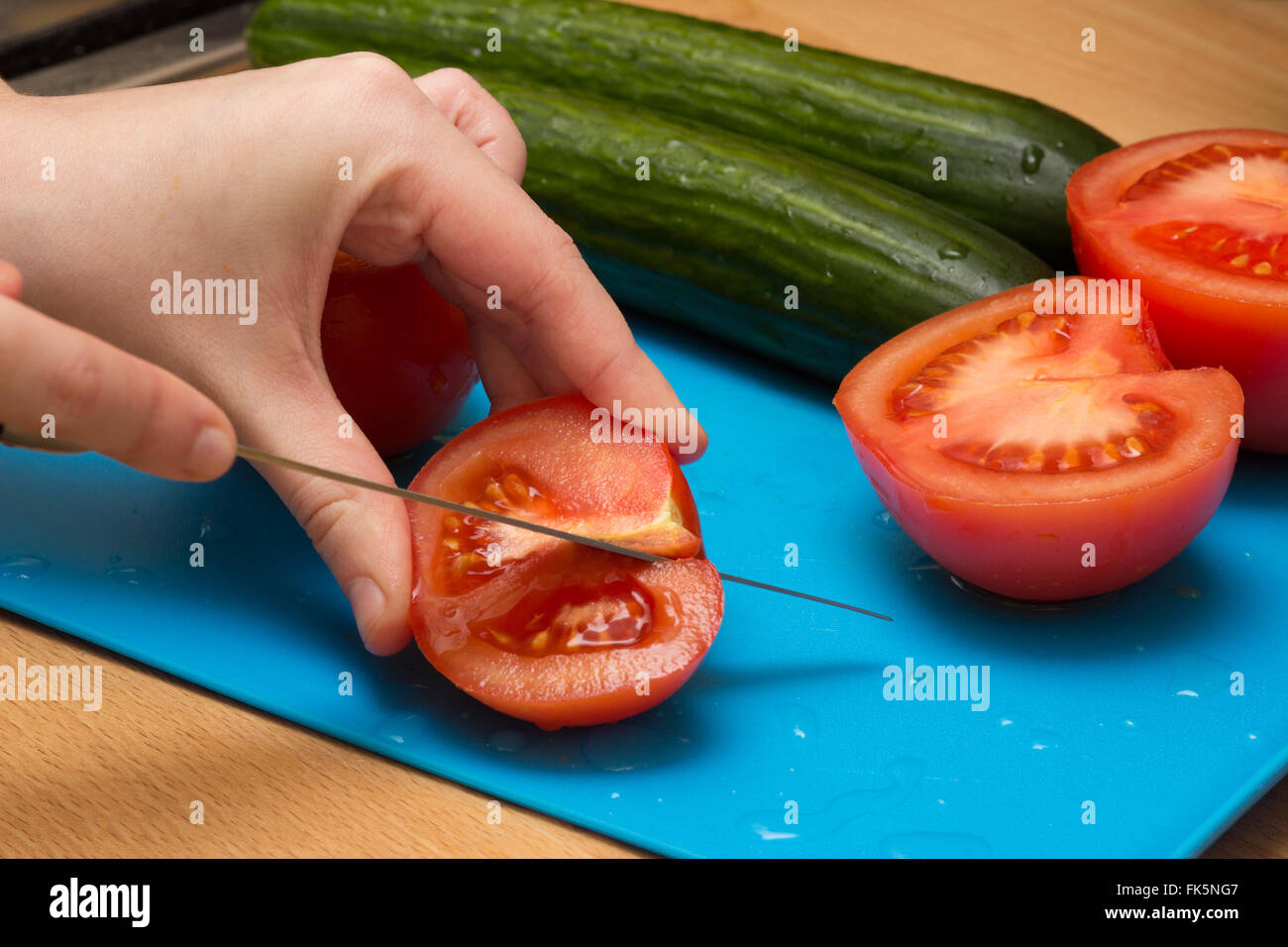 Close up de couper les tomates et concombres Banque D'Images