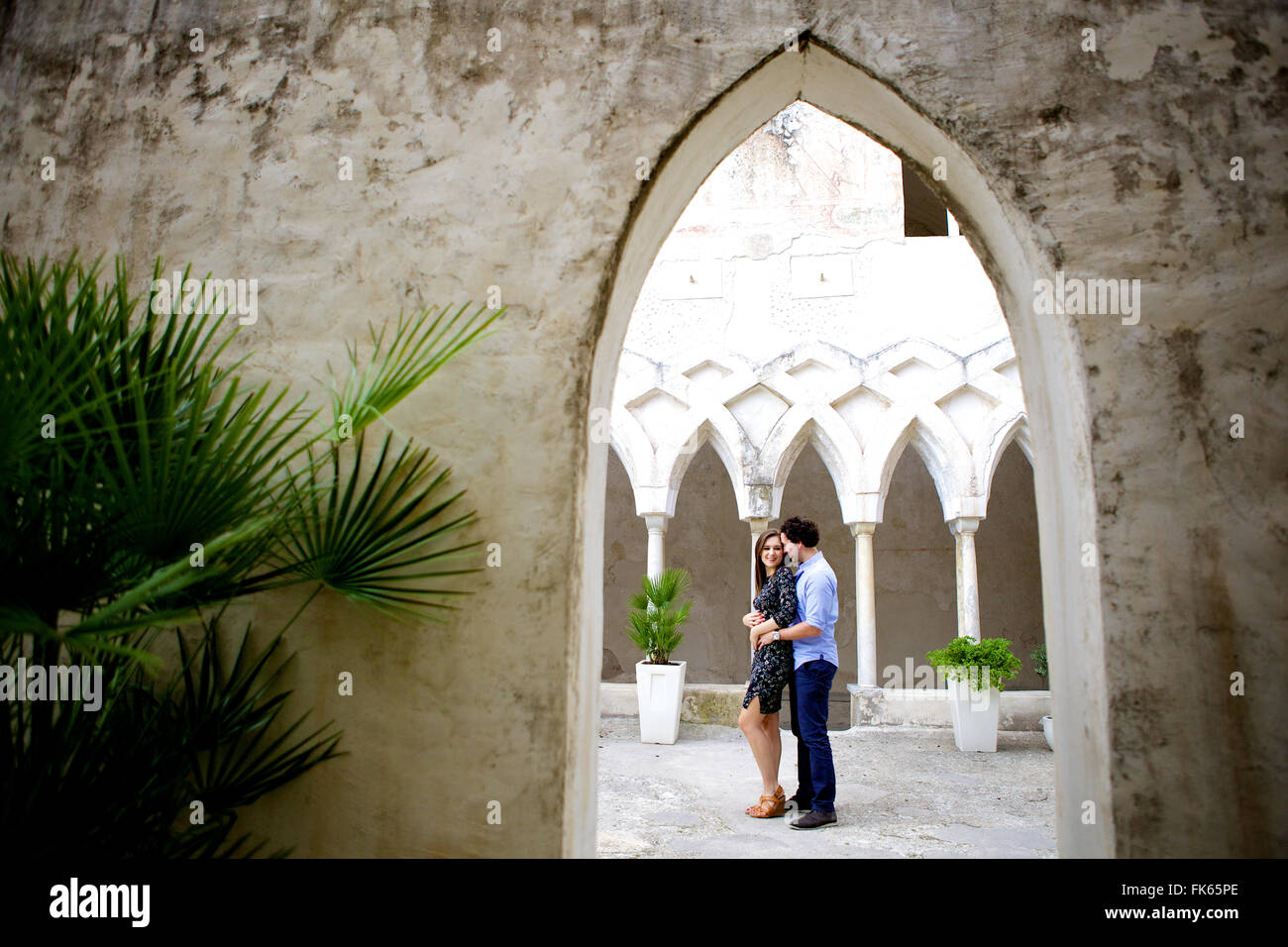 Un jeune couple brunette et dans l'amour dans le parc d'une ancienne et traditionnelle italienne historique, magnifique monastère, de grandes fenêtres Banque D'Images