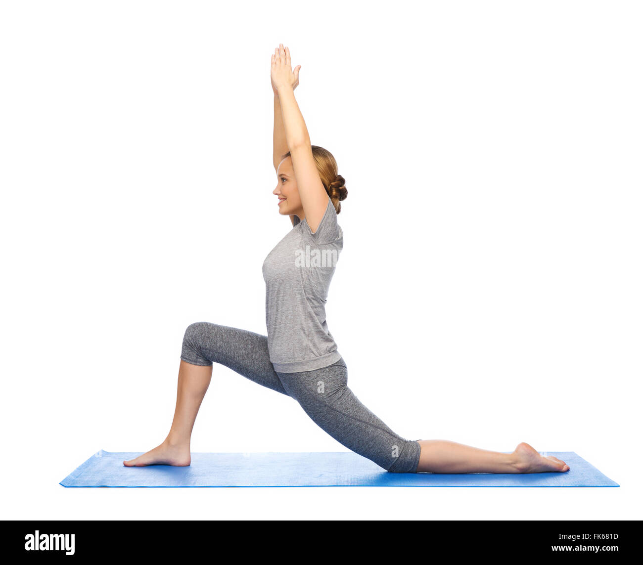 Happy woman in yoga mat sur fente basse Banque D'Images