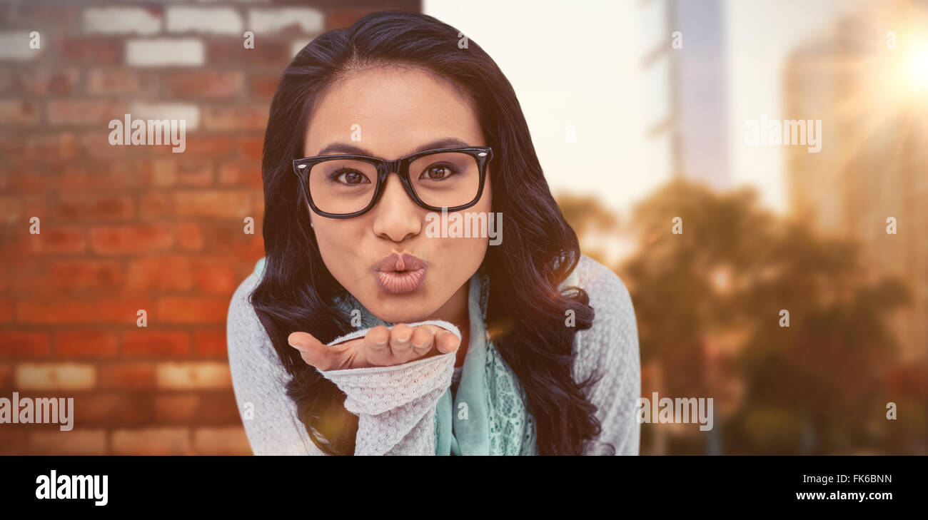 Composite image of asian woman blowing kiss à l'appareil photo Banque D'Images