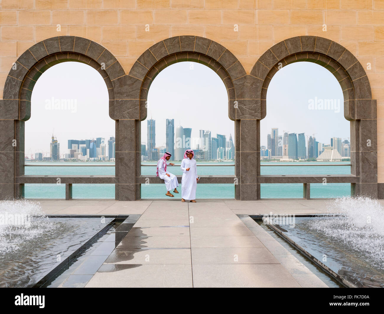 Deux hommes de l'endroit et les toits de quartier financier de Doha au Musée d'Art islamique de Doha au Qatar Banque D'Images