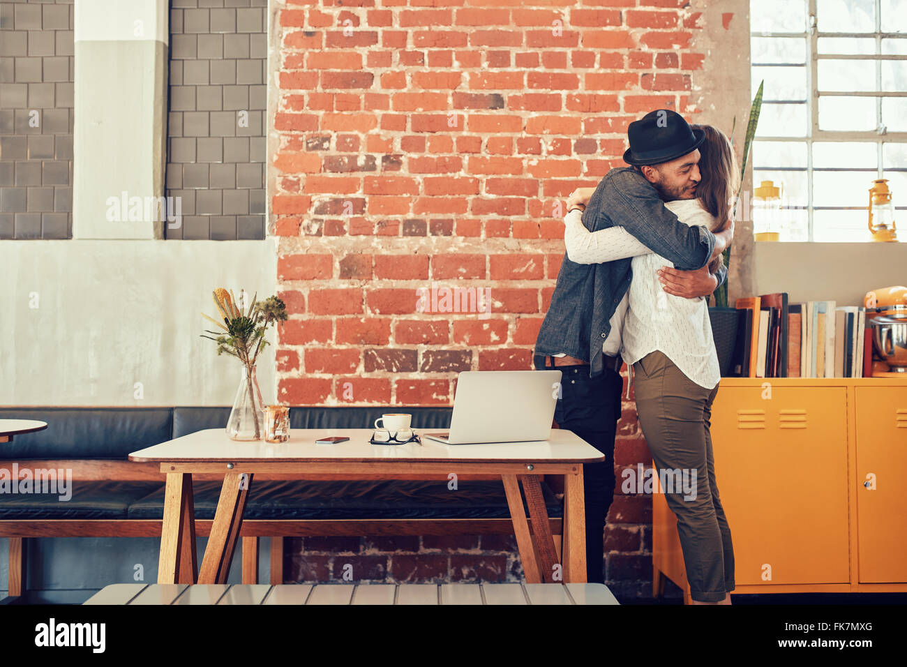 Portrait of man and woman hugging et saluant les uns les autres au café, en couple rencontre dans un café. Banque D'Images