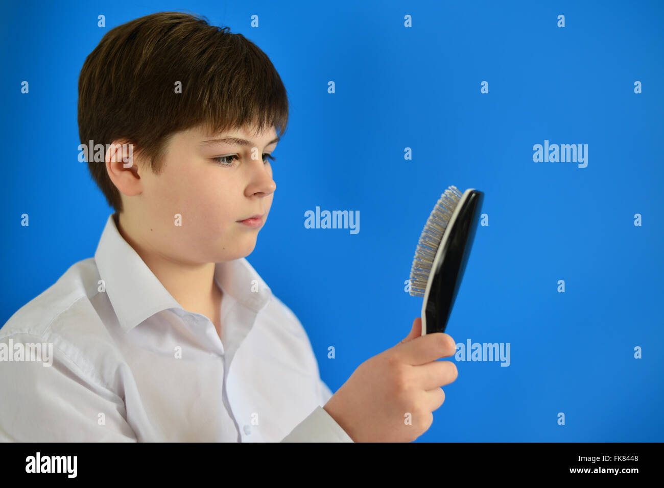 Garçon adolescent avec le peigne dans la main Photo Stock - Alamy