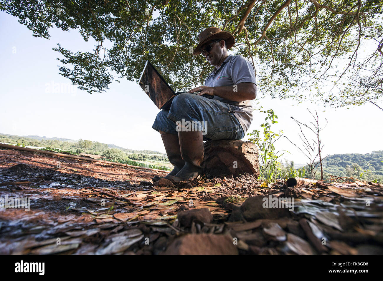 Farmer using computer in field Banque D'Images