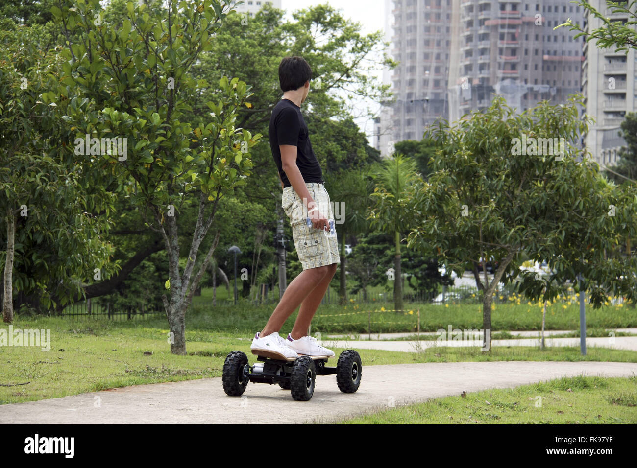 Les jeunes en skateboard motorisé avec People's Park dans le quartier Itaim Bibi Banque D'Images