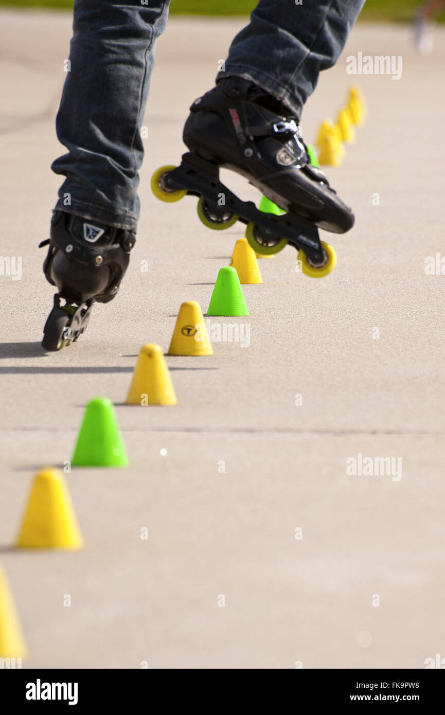 Skater évitant les obstacles sur le terrain dans le parc Banque D'Images