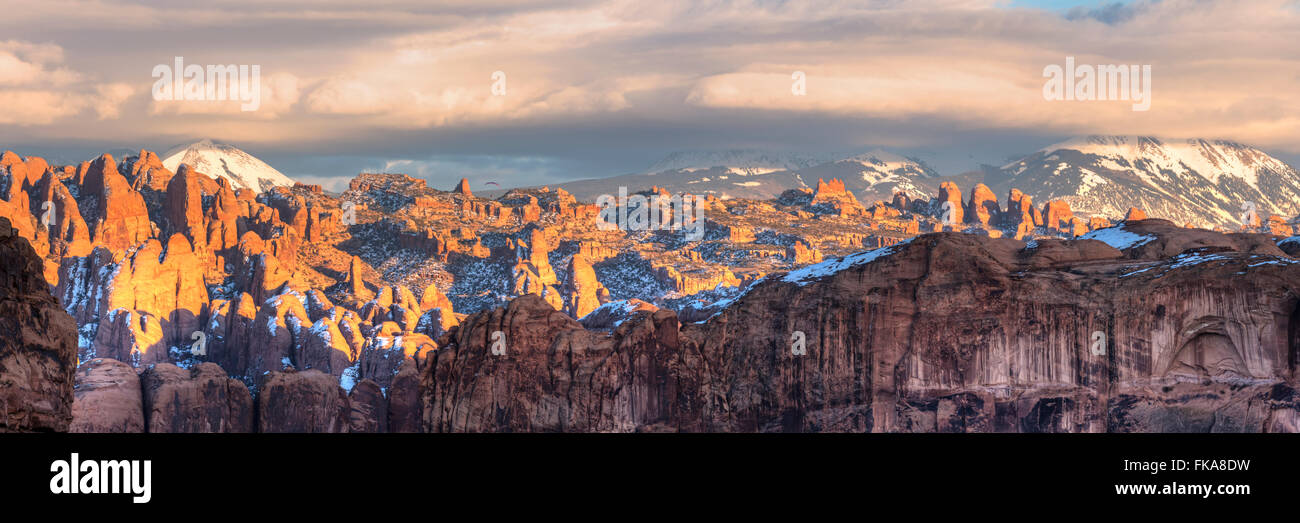 Les derniers rayons du soleil frappent la fine de grès dans la région sauvage derrière les roches avec Montagnes La Sal derrière dans Moab, Utah Banque D'Images