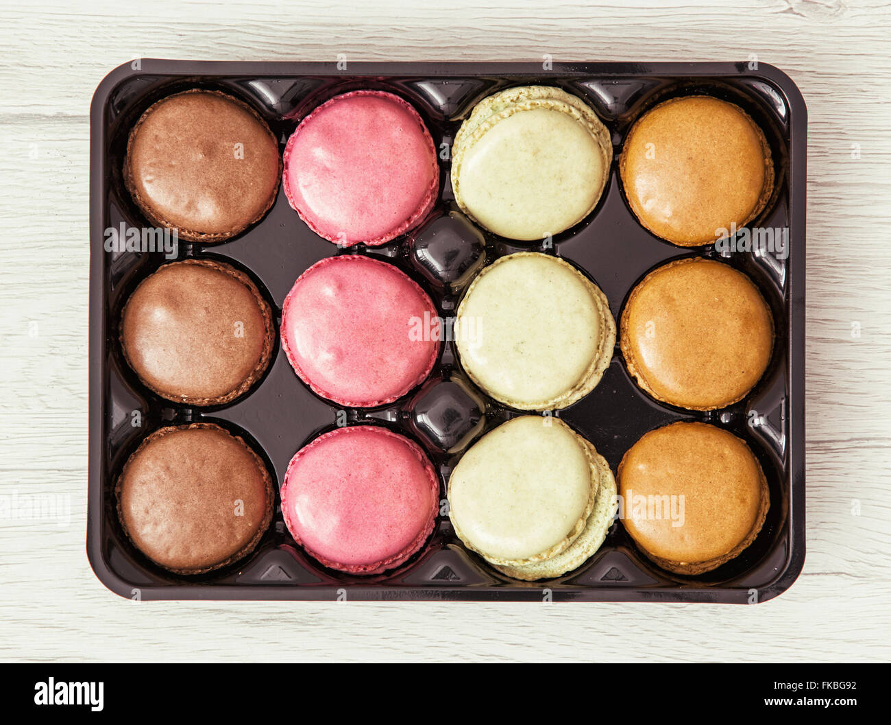 Délicieux macarons dans le noir fort. Un aliment sucré. Banque D'Images